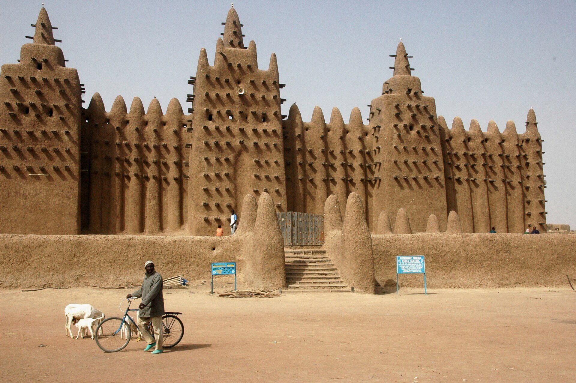 The earthen Great Mosque of Djenné with a man and bicycle in the foreground